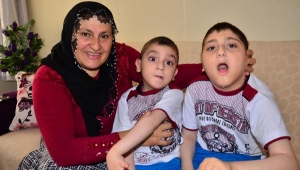 Engelli iki çocuğuna bebek gibi bakıyor