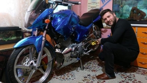Modifiye motosikletini evinin salonuna park ediyor